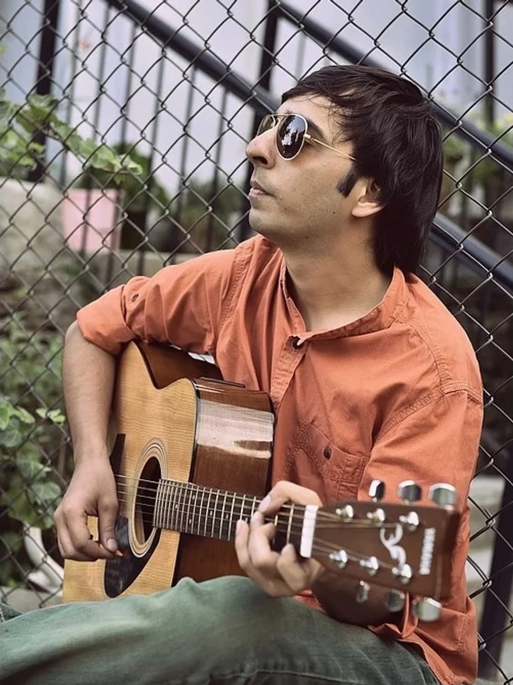 Ishan Khera sitting with an acoustic guitar